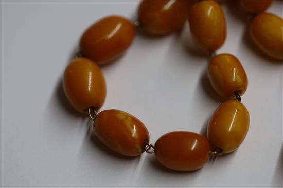 A single strand graduated oval amber bead necklace, 95cm.